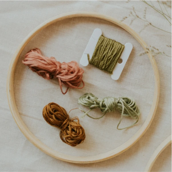 Tambour à broder vierge avec des echevettes de couleurs, attendant d'etre broder